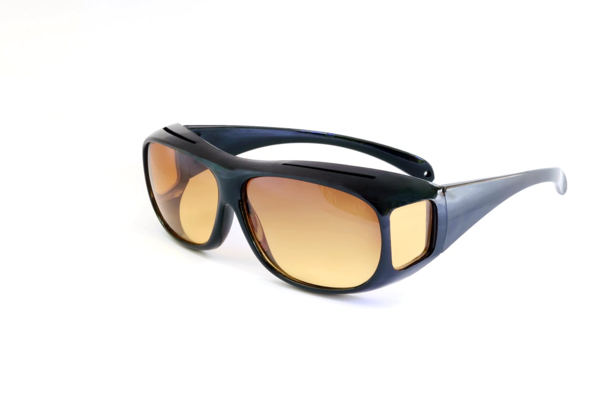 Close-up of amber-tinted fit-over sunglasses for macular degeneration protection
