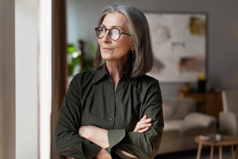 Confident mature businesswoman standing with arms crossed, representing independence and mastery of aging logistics