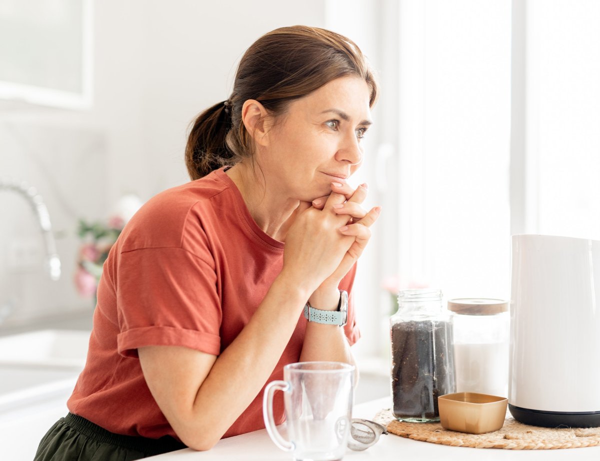 Thoughtful Woman At Home In The Kitchen