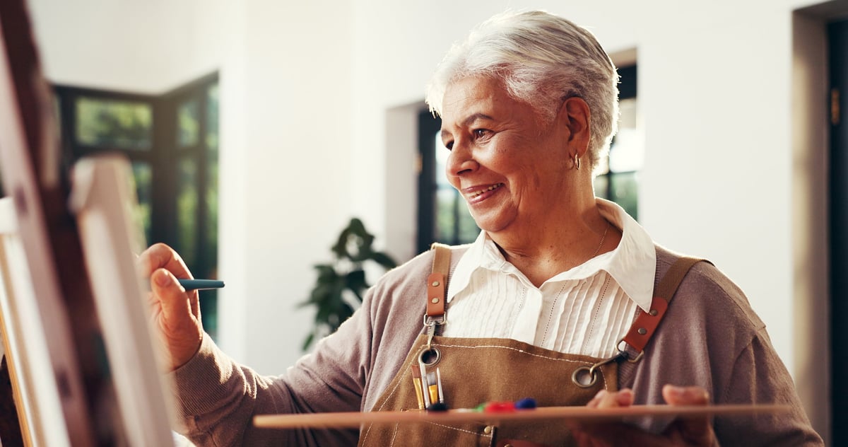 Senior woman, home and artist painting for creative self expression, talent or art. Retirement hobby, painter and canvas for artwork, inspiration or happy elderly person drawing with brush in house