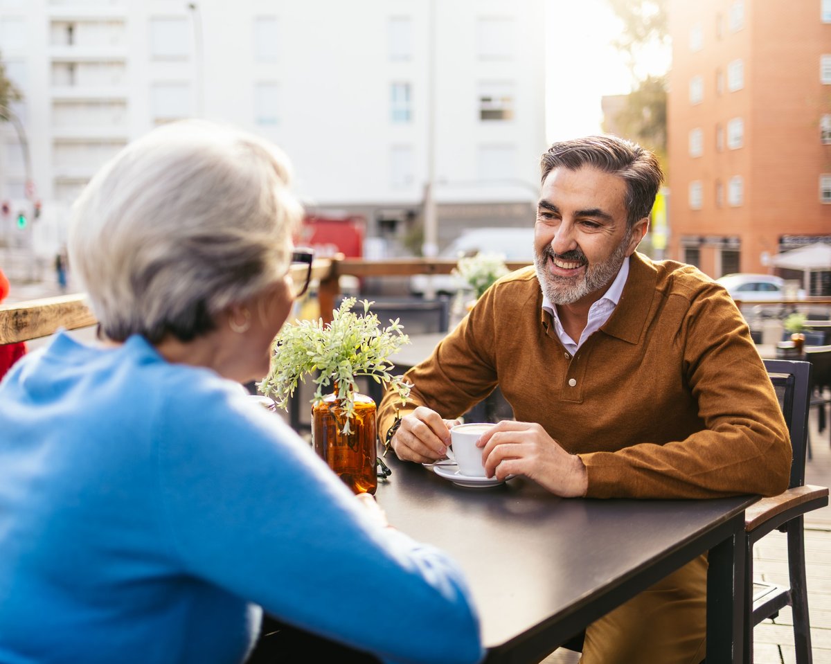Senior couple sharing an active conversation at outdoor cafe